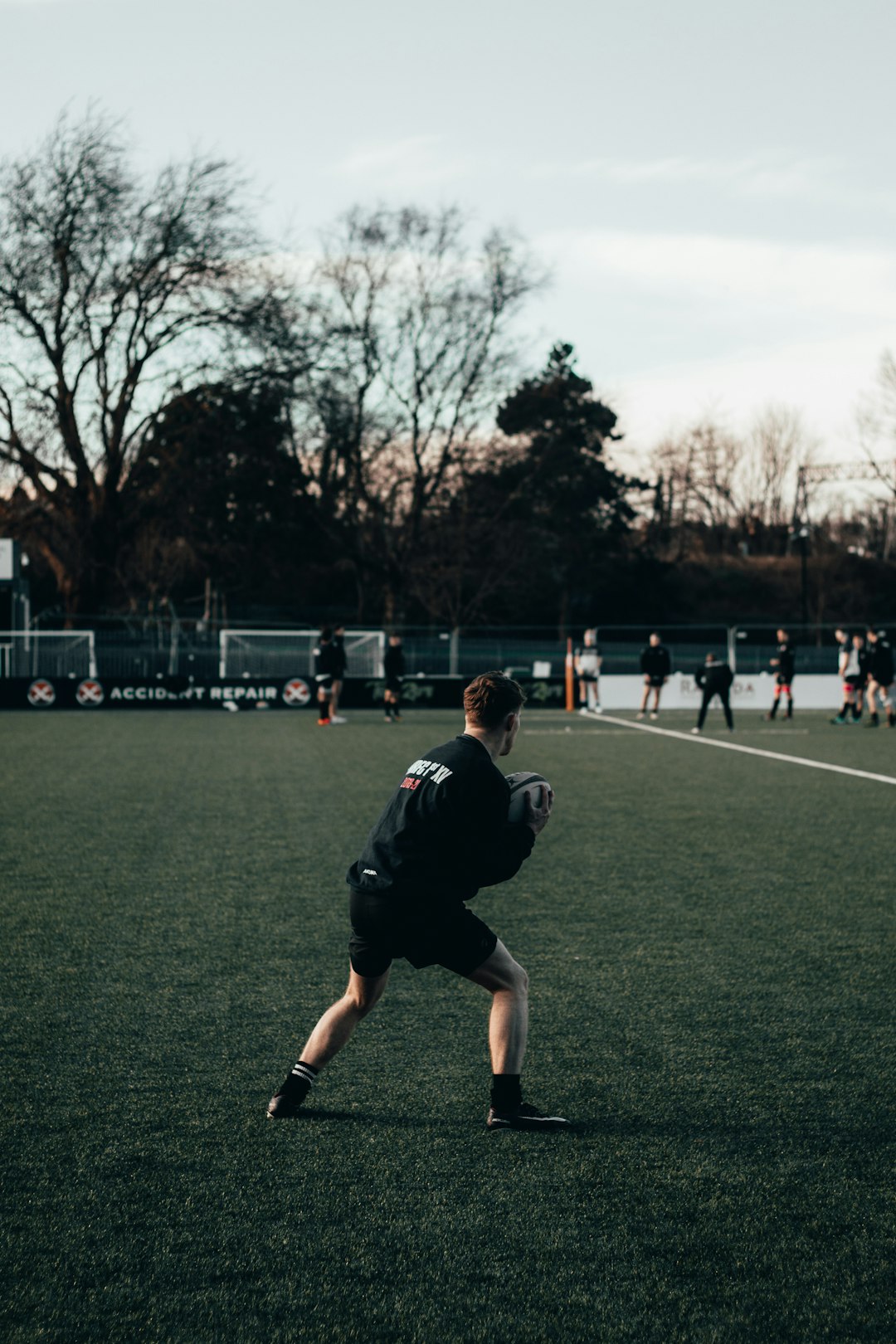 man in black soccer jersey shirt running on green grass field during daytime