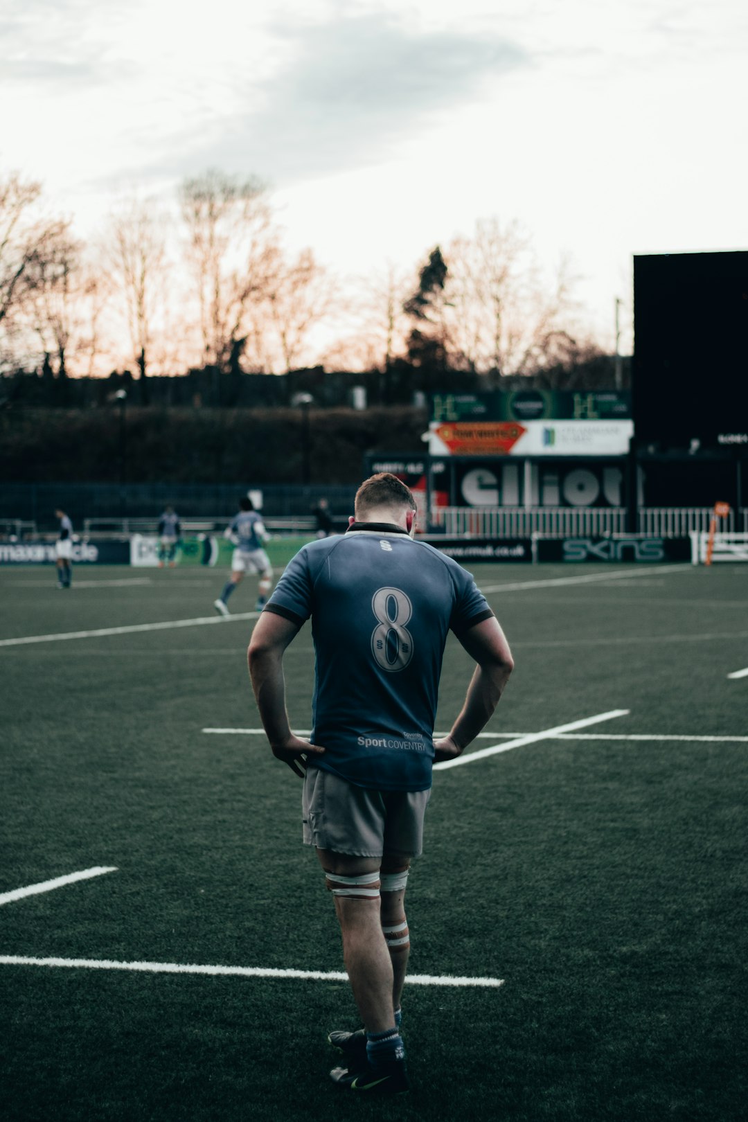 man in black nike jersey shirt and gray shorts standing on green field during daytime