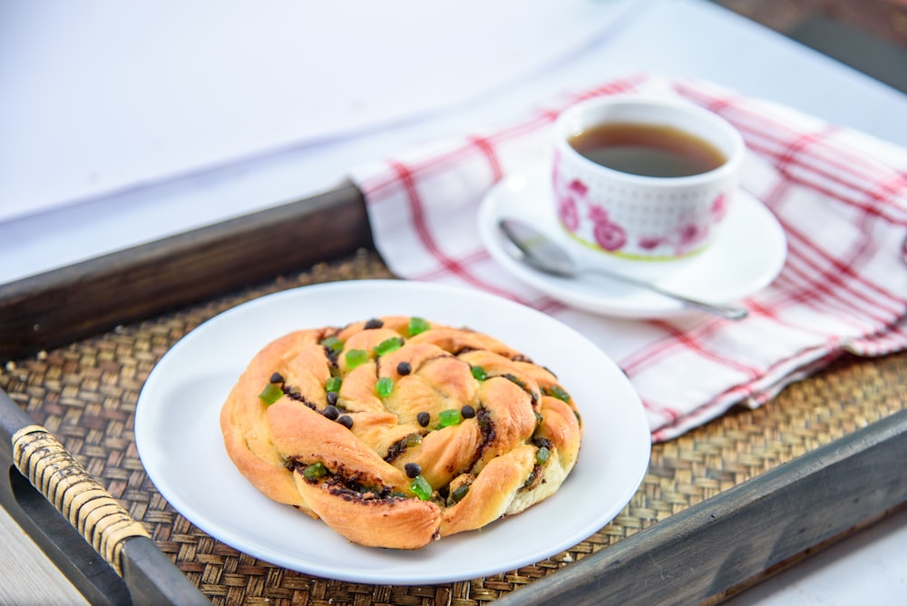 bread on white ceramic plate beside white ceramic mug with coffee