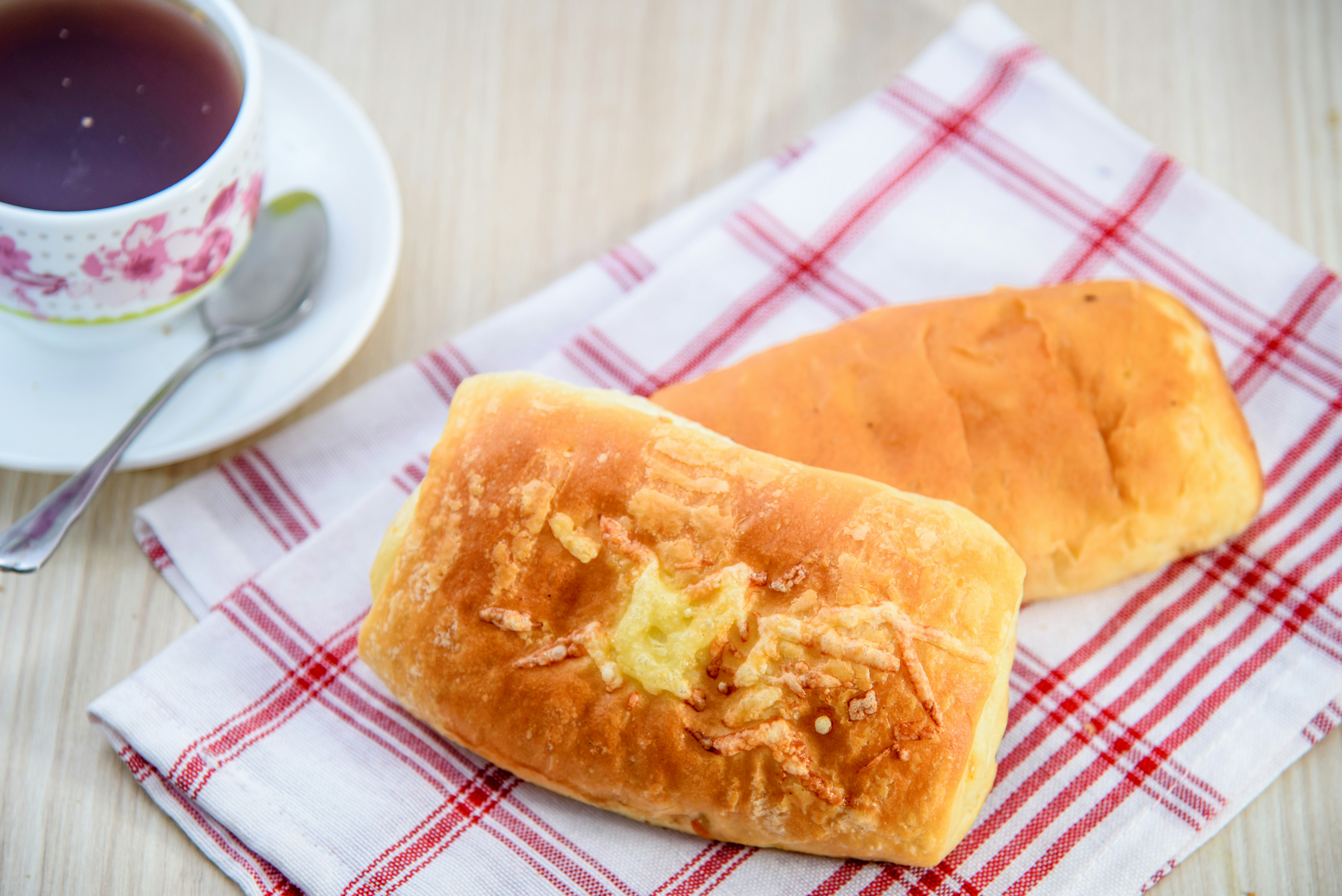 Roti dengan keju parut panggang di atas serbet kotak-kotak merah
