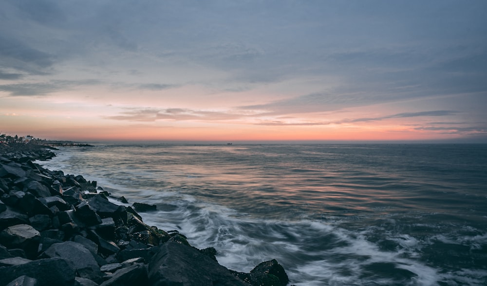 Les vagues de l’océan s’écrasent sur les rochers au coucher du soleil