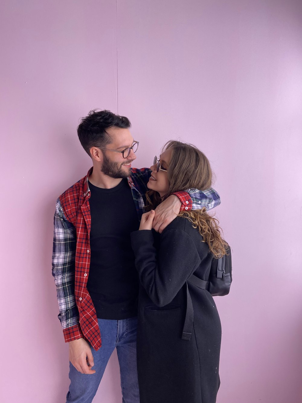 homem no terno preto beijando a mulher na camisa social xadrez vermelha branca e azul