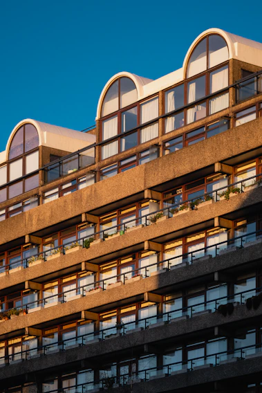 A striking view of Wisma Equity's raw concrete facade bathed in morning light, highlighting its brutalist architecture.