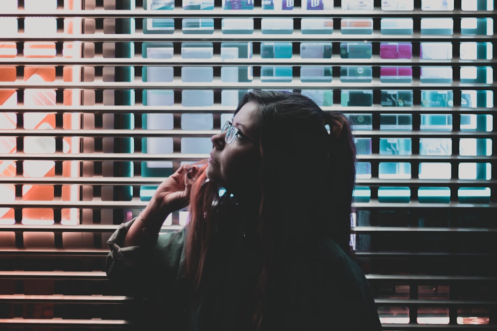 woman in black long sleeve shirt sitting beside window