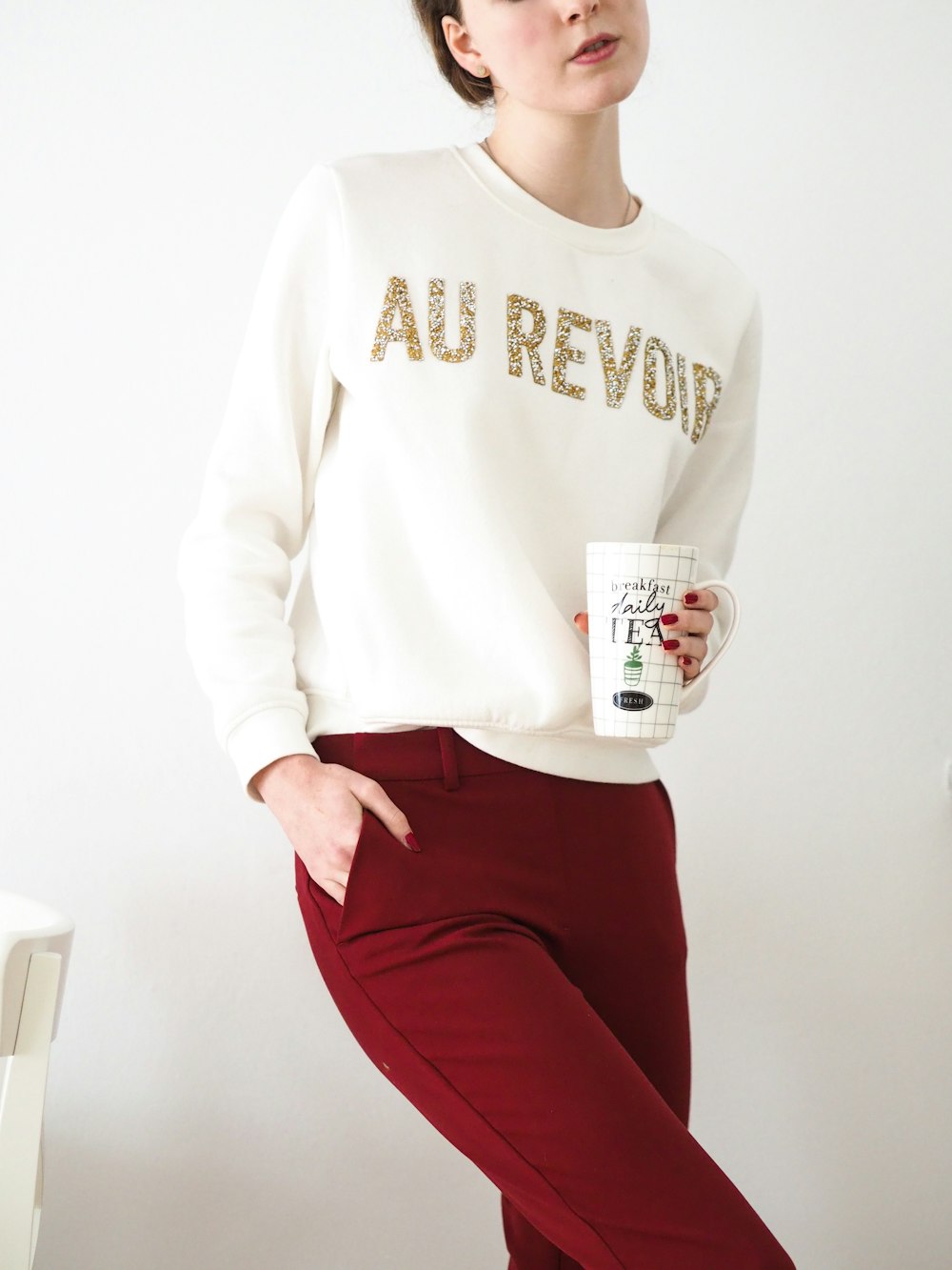 woman in white long sleeve shirt and red pants