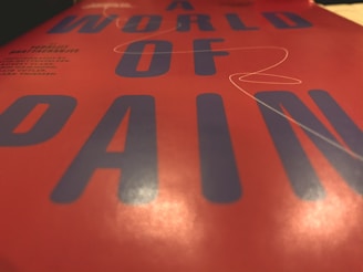 Close-up of a glossy flyer with bold red accents on black background.