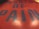 Close-up view of bold typography featuring large blue letters on a red background, with the words forming a phrase centered in the image. The surface has a reflective and glossy texture.