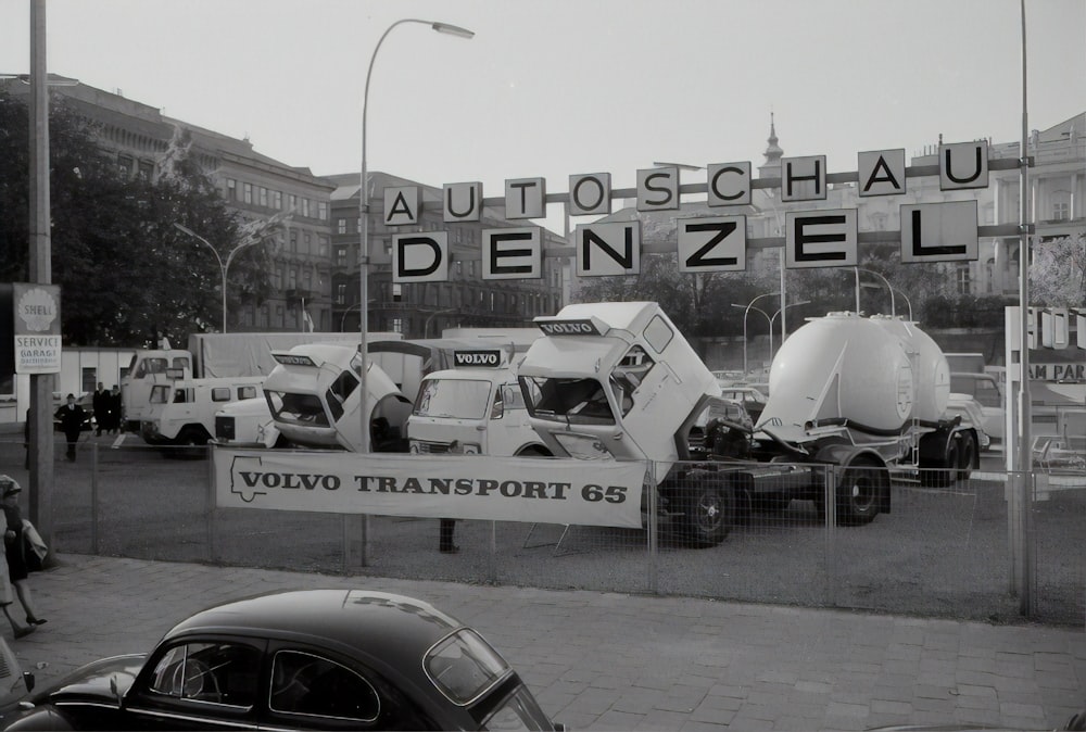 grayscale photo of cars parked beside building