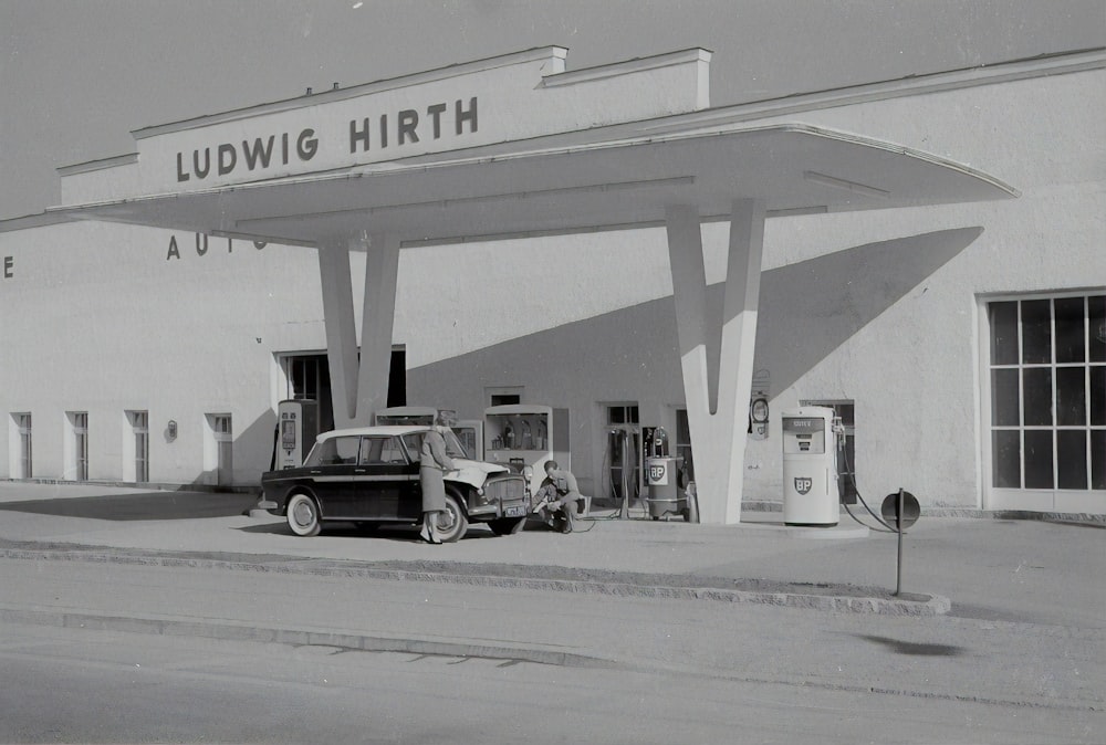 white and black cars parked in front of white and blue building