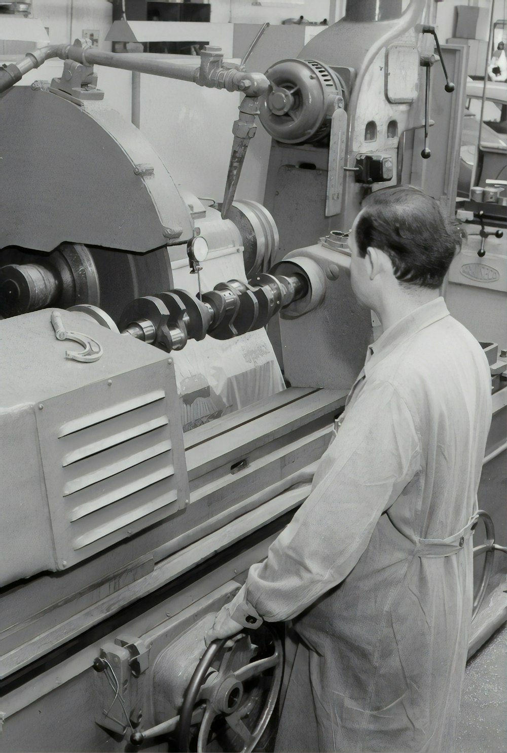 man in white shirt standing in front of white and black machine