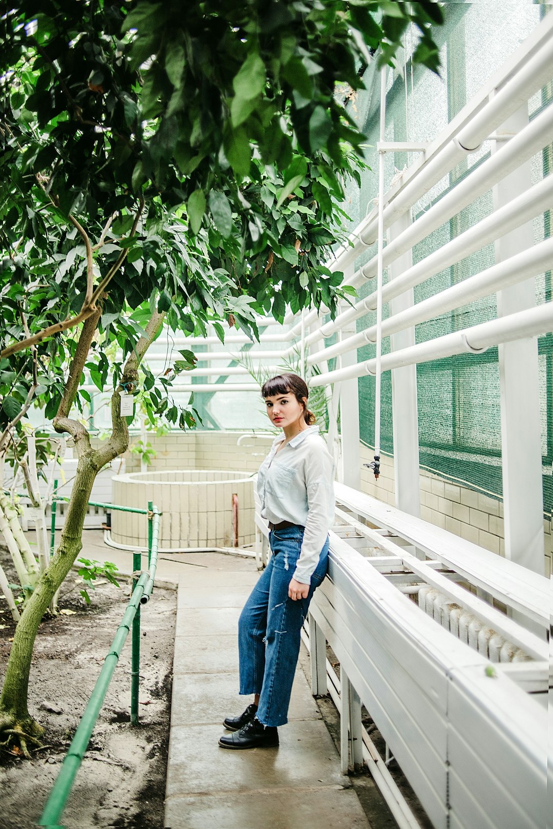 woman in white long sleeve shirt and blue denim jeans standing on white staircase