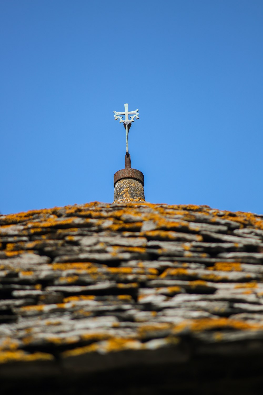 cross on top of brown brick wall