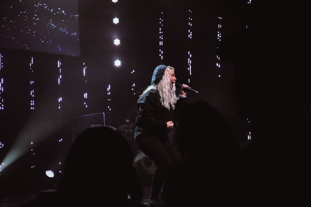 woman in black jacket singing on stage