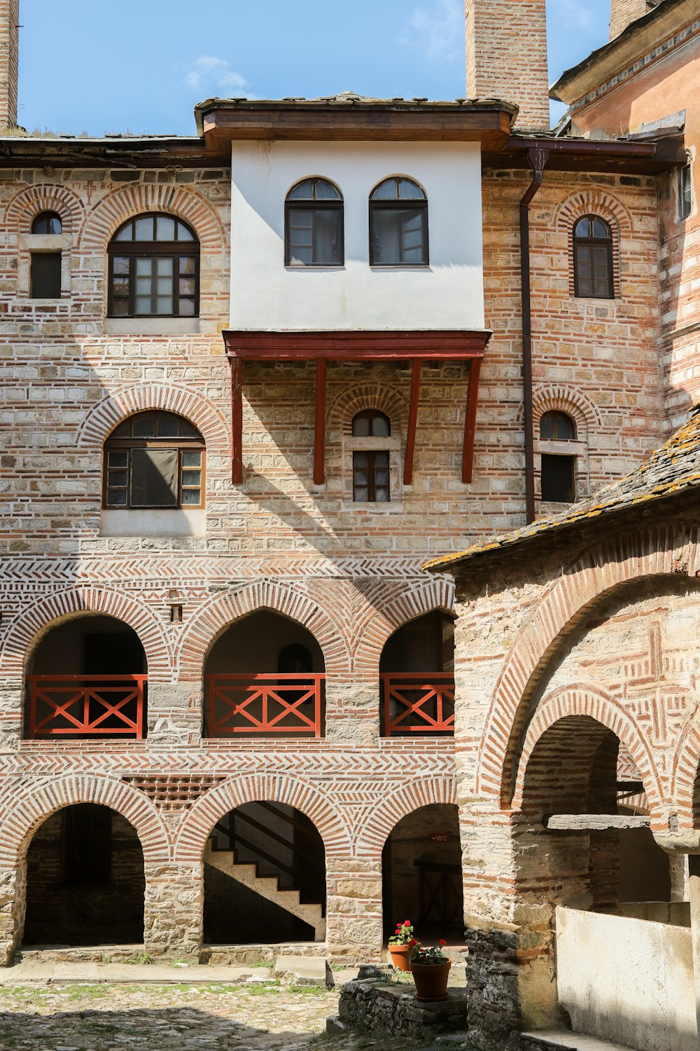 a large brick building with arches and a clock tower