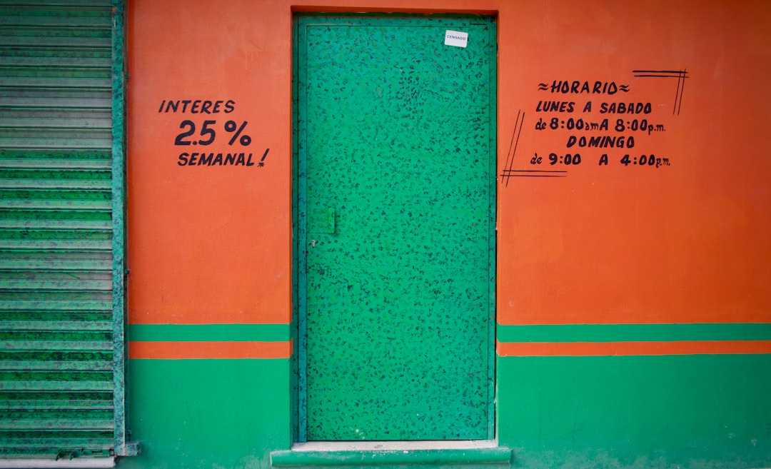 brown wooden door with red and white painted wall, Green door