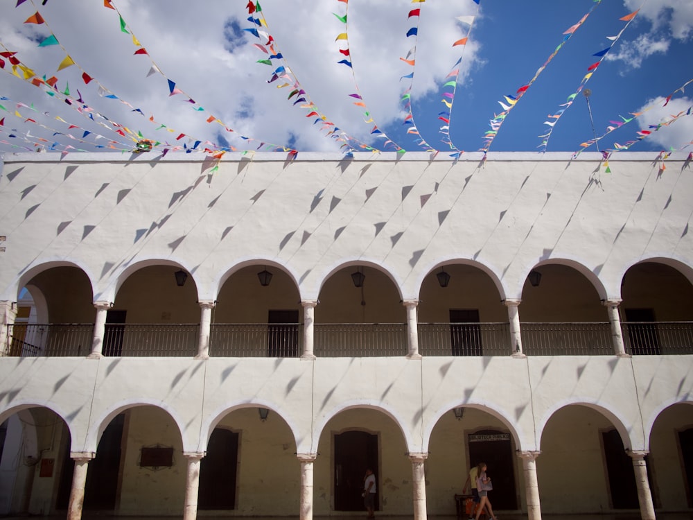 white concrete building with multi colored balloons on top