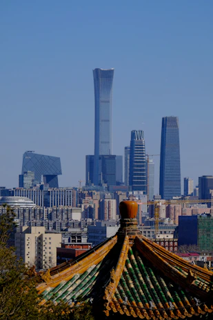 An elegant shot of a historic Chinese palace blending with modern skyscrapers in the background.