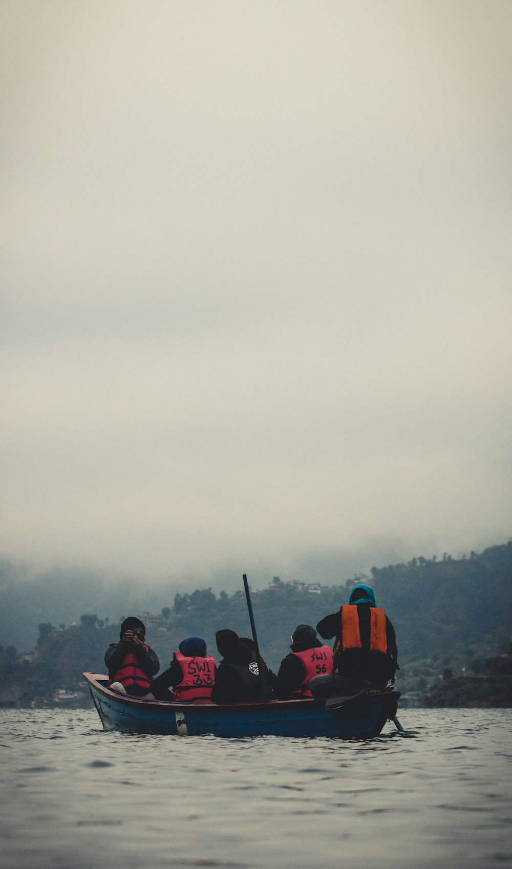 people in red and black jacket sitting on red chair during daytime