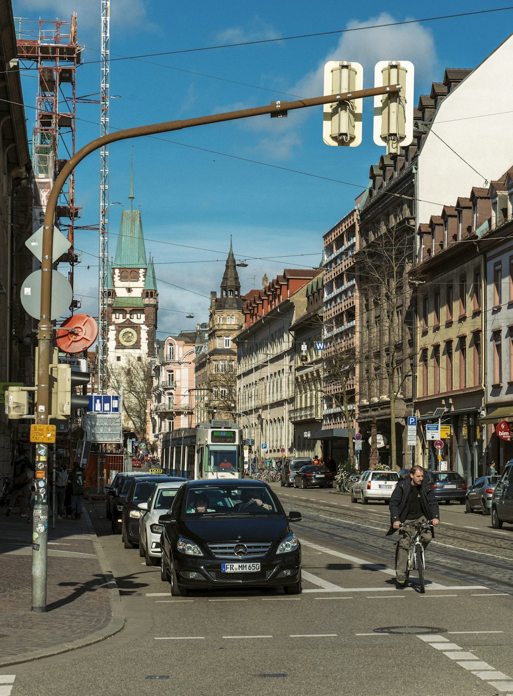 black car on road near people walking on sidewalk during daytime