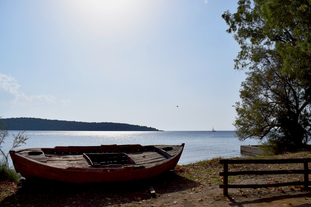 brown wooden boat on beach during daytime