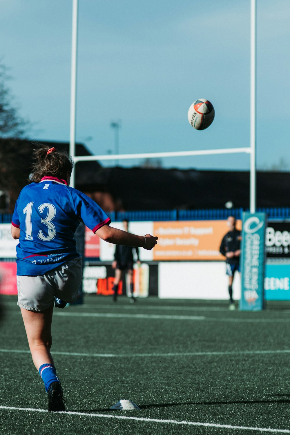 man in blue and white soccer jersey kicking ball during daytime