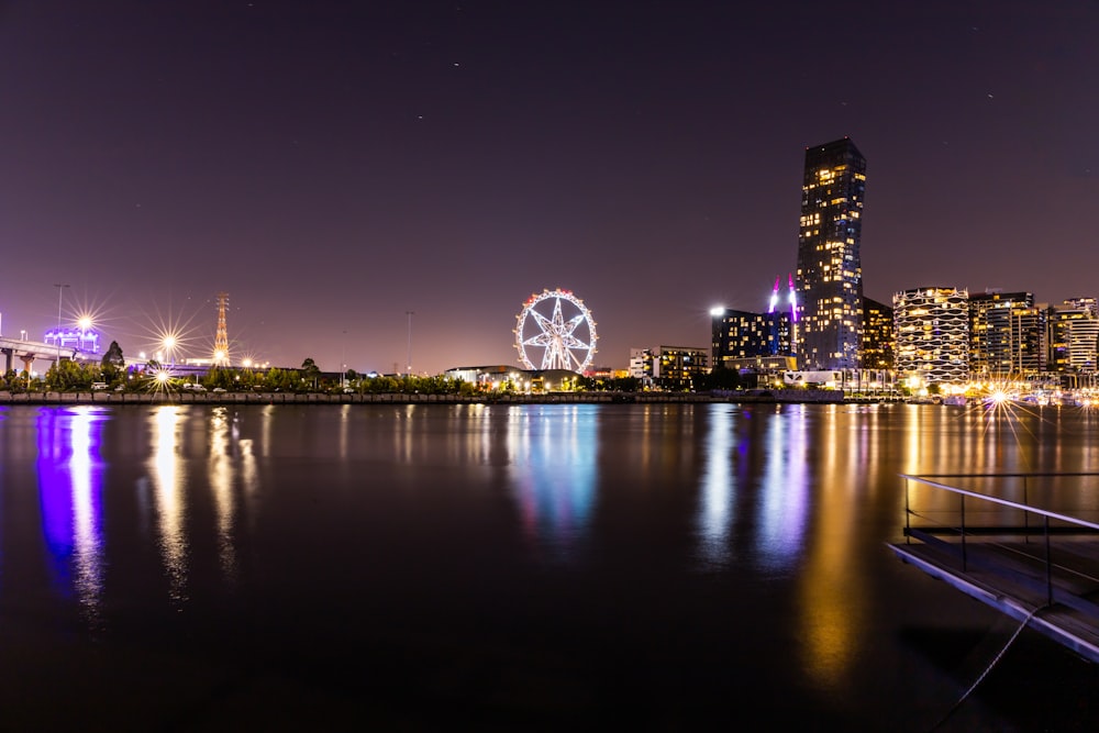 a night view of a city with a ferris wheel in the distance