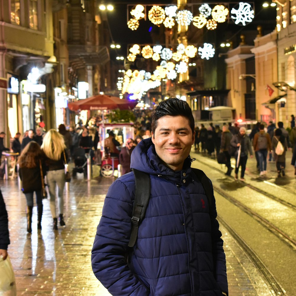 man in black bubble jacket standing on street during night time