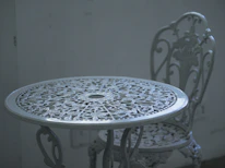 Close-up of a vintage outdoor console table with intricate metalwork and a rustic finish.