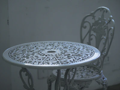 Close-up of a vintage outdoor console table with intricate metalwork and a rustic finish.