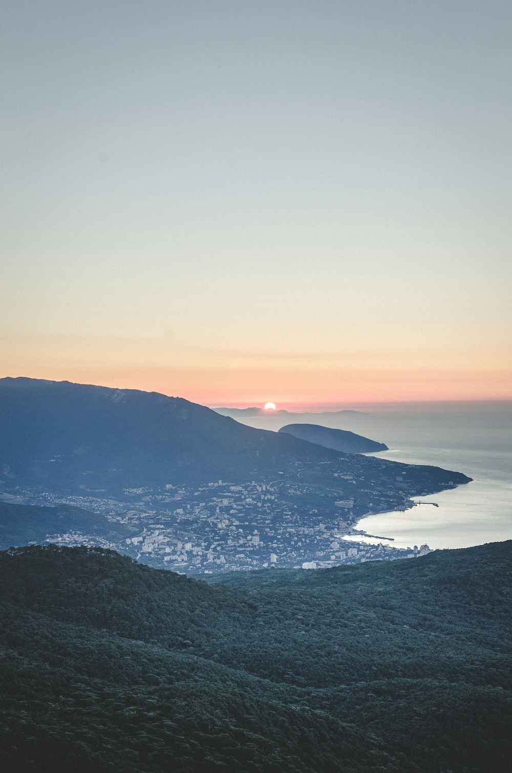aerial view of mountains and body of water during sunset