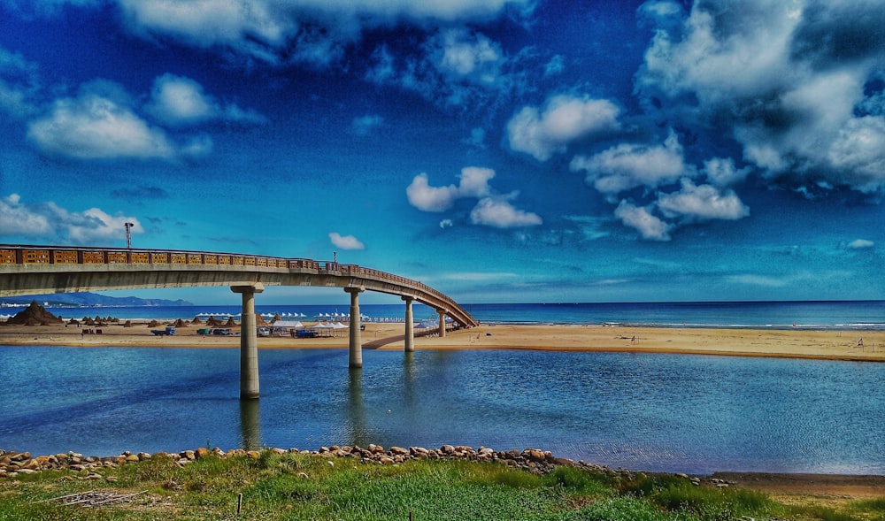 gray concrete bridge over blue sea under blue sky during daytime