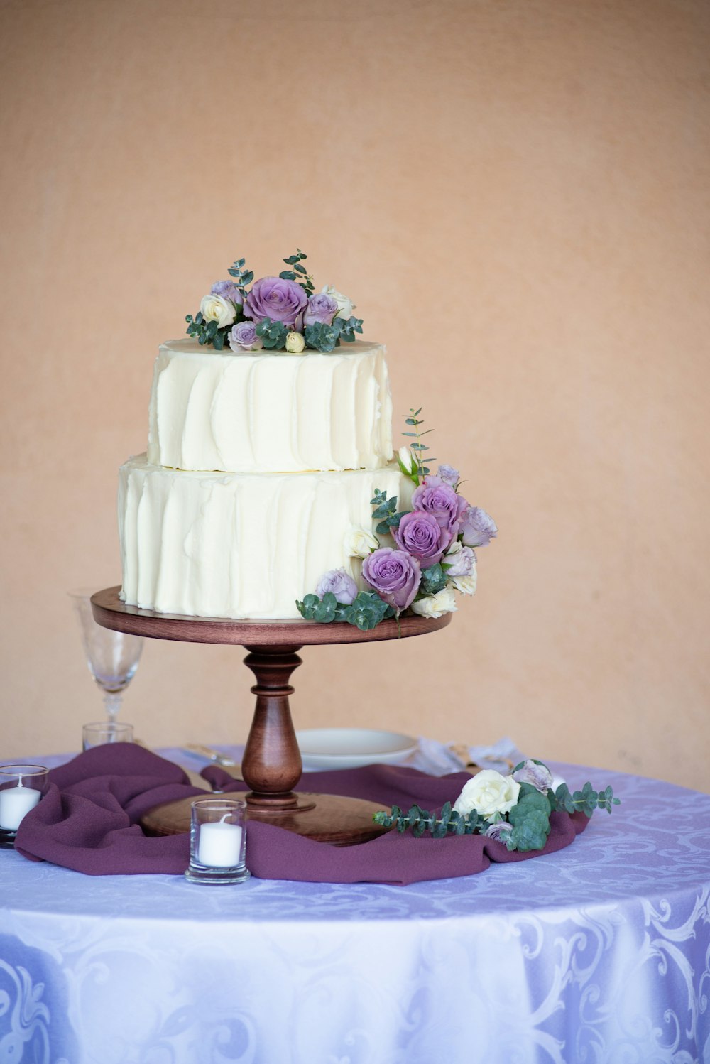 white and pink floral cake on brown wooden stand