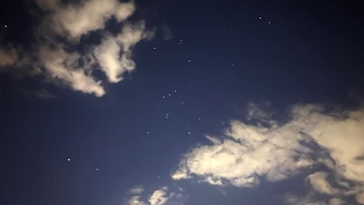 A glowing kundli chart illuminated against a starry night sky with soft gold accents.