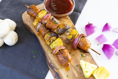 Grilled skewers with colorful vegetables and juicy meat on a rustic wooden board.
