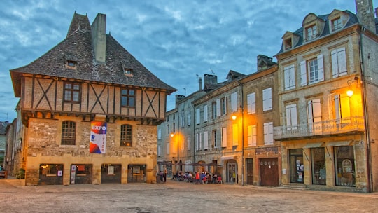 people walking on street near brown concrete building during daytime in Saint-Céré France