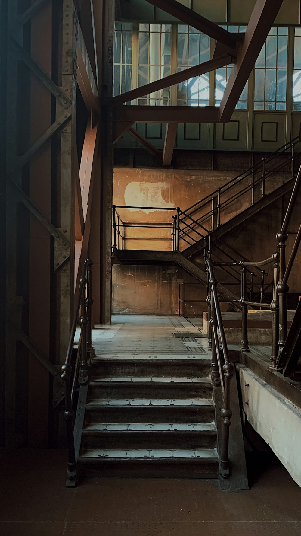 Escalier en bois brun avec rampes en acier inoxydable