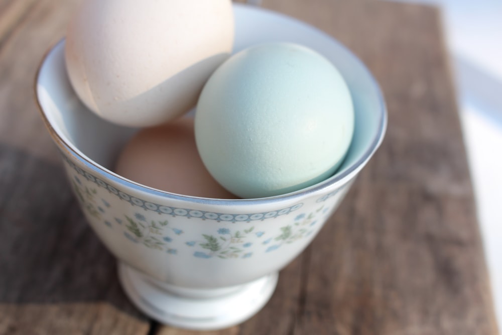 white egg on white and blue floral ceramic bowl