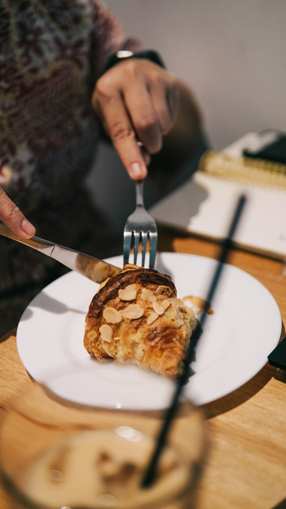 person holding stainless steel fork and white ceramic plate