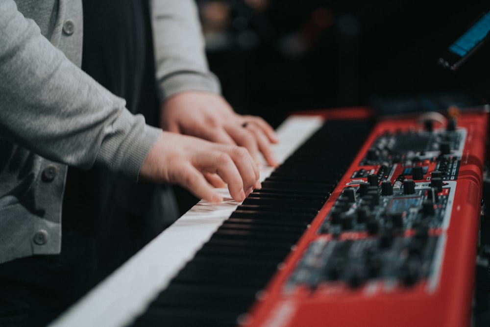 person playing red and white piano