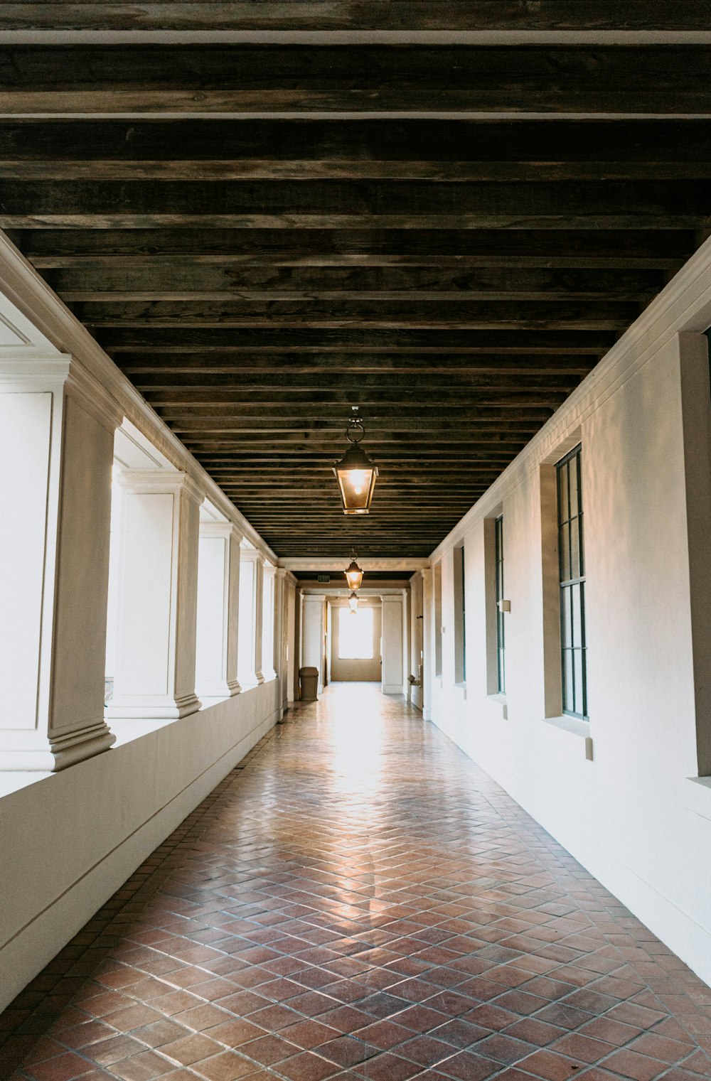 brown wooden hallway with white walls