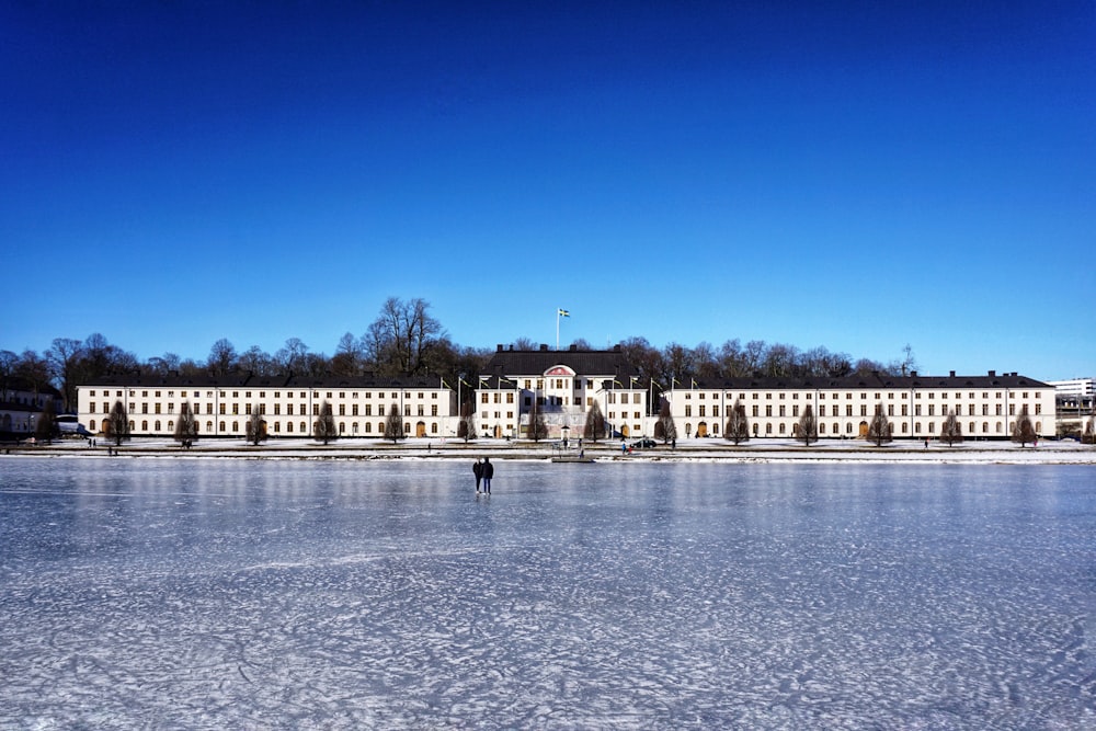 white concrete building near body of water under blue sky during daytime