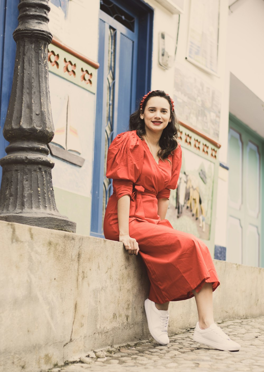 woman in red dress sitting on concrete bench