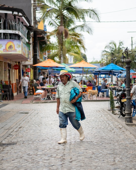 woman in blue denim jacket and blue denim shorts walking on sidewalk during daytime in Guatape Colombia