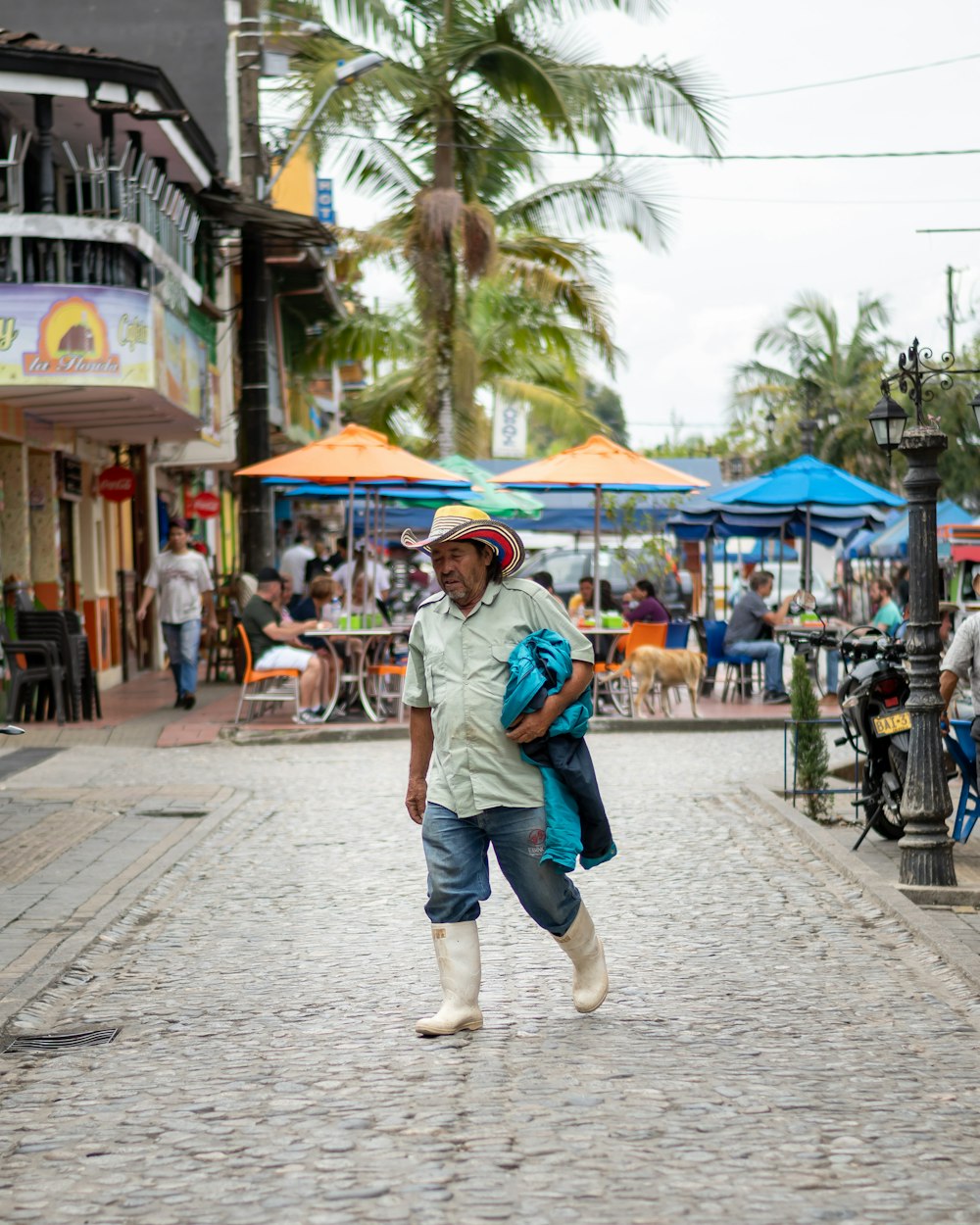 woman in blue denim jacket and blue denim shorts walking on sidewalk during daytime