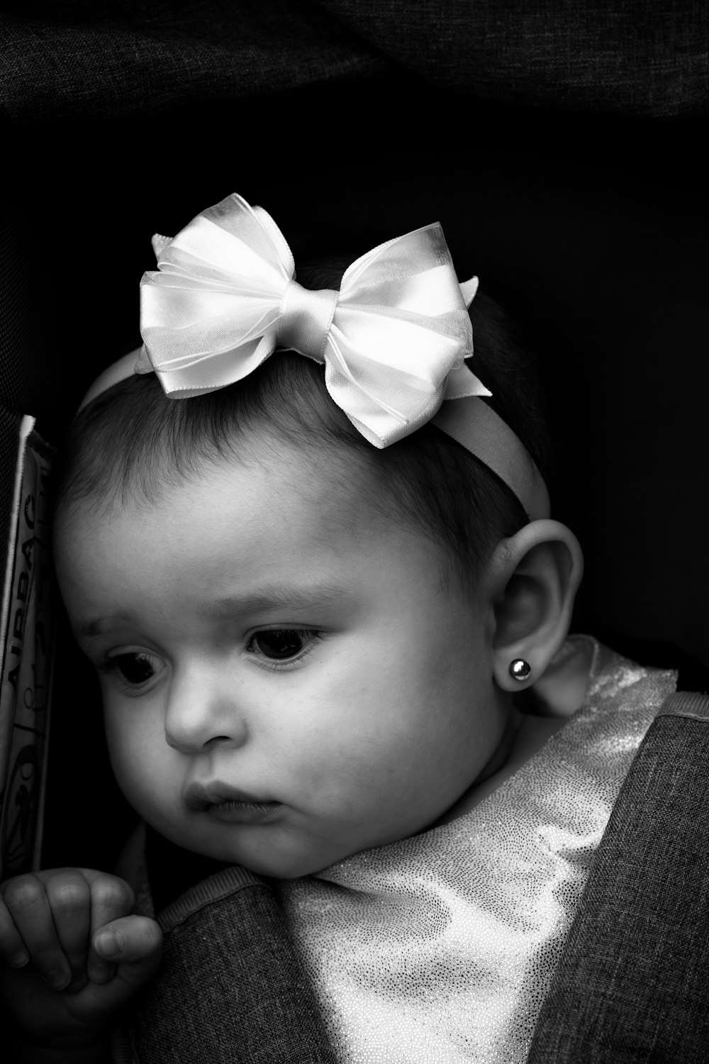 grayscale photo of baby wearing white ribbon