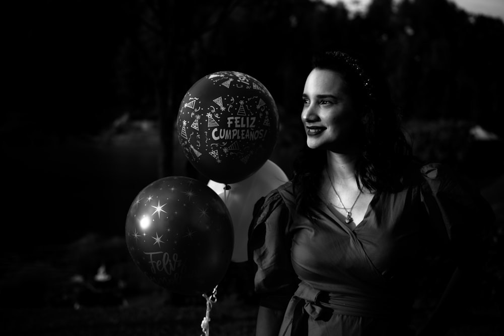 Femme en veste en cuir noir tenant un ballon de joyeux anniversaire