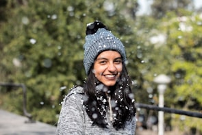 A cozy winter beanie in deep blue, surrounded by soft snowflakes.