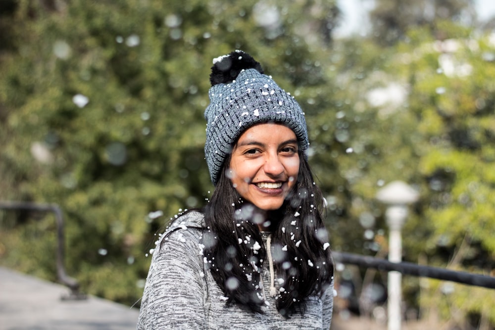 woman in gray knit sweater and blue knit cap