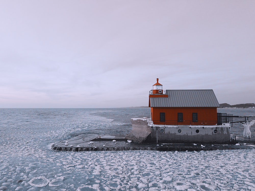 red and black house on the sea during daytime