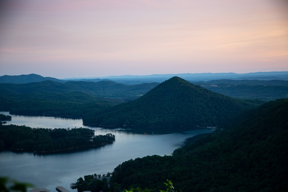 green mountain beside body of water during daytime